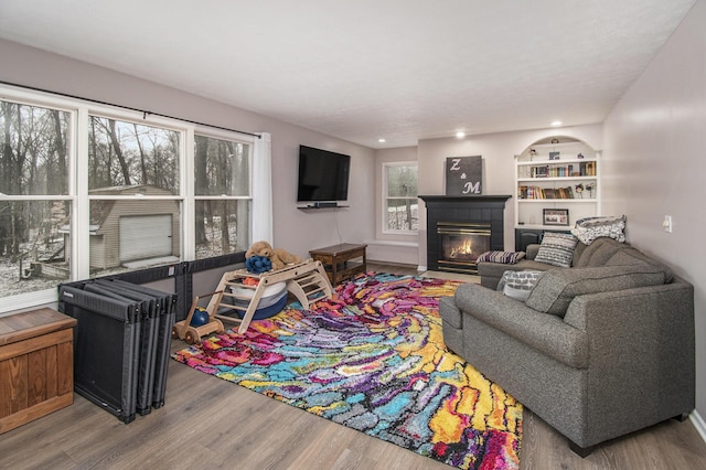 living room with a tile fireplace and wood finished floors