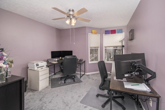 carpeted home office featuring baseboards, a ceiling fan, and a textured ceiling