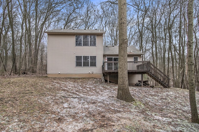 rear view of property featuring stairway and a deck