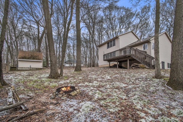 exterior space featuring an outdoor fire pit, stairway, an outdoor structure, and a wooden deck