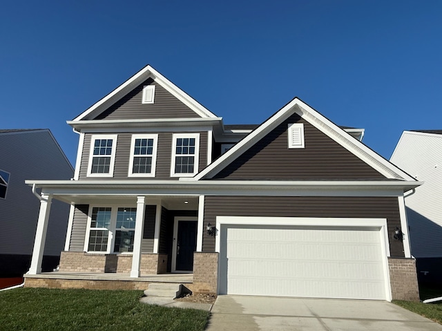 craftsman-style house featuring a garage, brick siding, and driveway