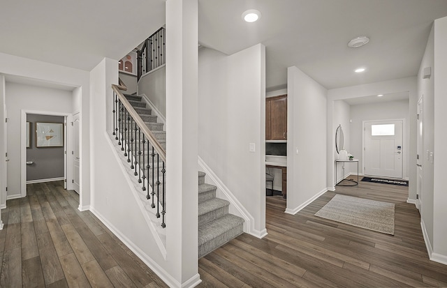 stairway featuring recessed lighting, wood finished floors, and baseboards