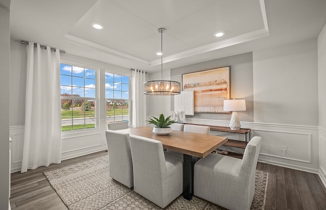 dining room featuring a wainscoted wall, crown molding, a tray ceiling, and wood finished floors