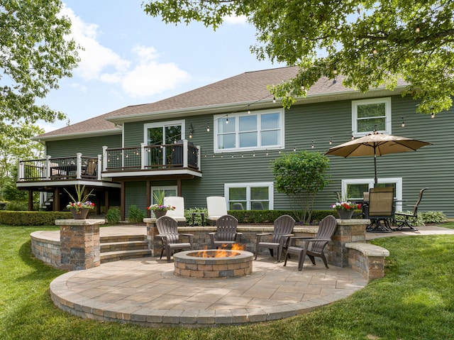 back of property with a patio, an outdoor fire pit, a yard, a shingled roof, and a wooden deck