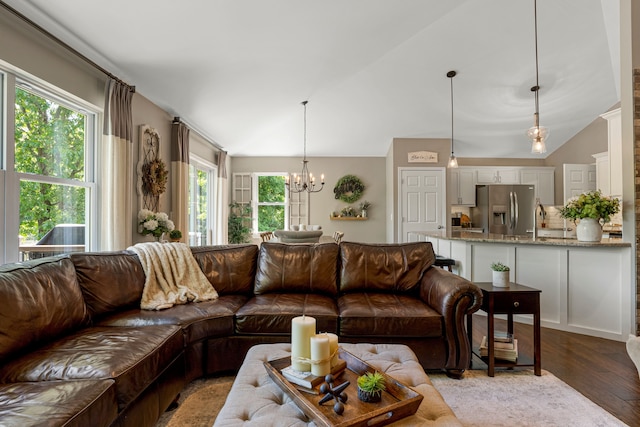 living room with a chandelier, light wood-type flooring, and vaulted ceiling