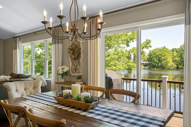 dining space featuring a notable chandelier, wood finished floors, and a water view