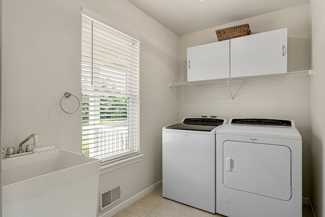 washroom with visible vents, baseboards, washer and clothes dryer, light tile patterned flooring, and a sink