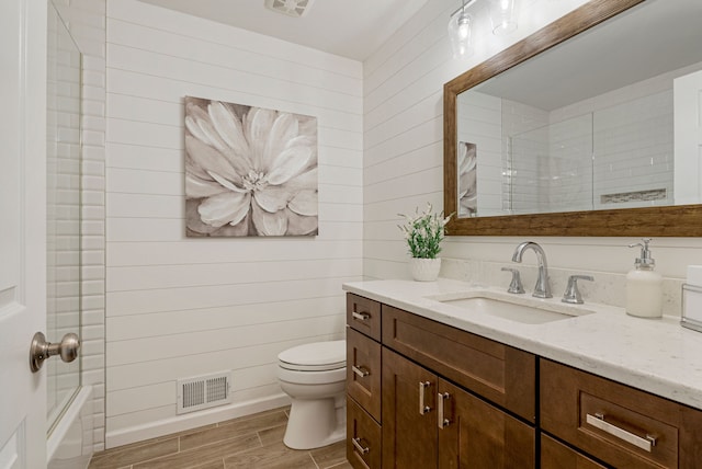 full bath with visible vents, toilet, wood tiled floor, baseboards, and vanity