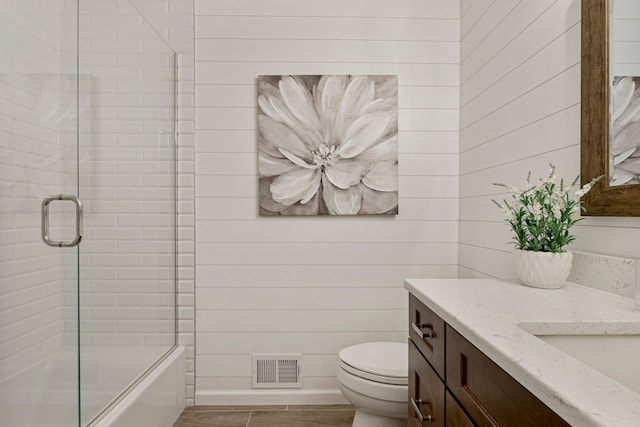 full bath with visible vents, toilet, combined bath / shower with glass door, baseboards, and vanity