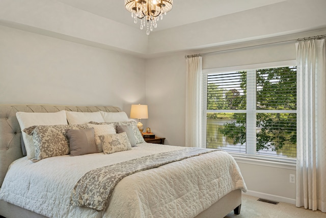 bedroom featuring light carpet, visible vents, multiple windows, and baseboards