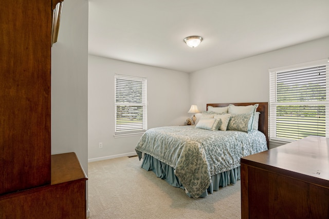 bedroom featuring baseboards and light carpet