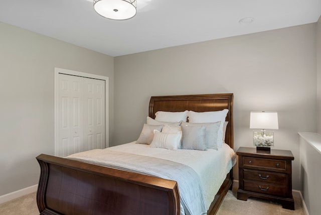 bedroom featuring baseboards, a closet, and light carpet