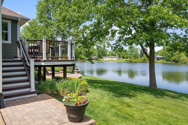 view of yard with stairway and a deck with water view