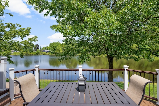 wooden terrace with outdoor dining space and a water view