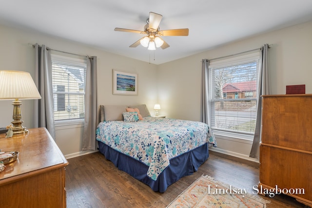 bedroom with a ceiling fan, multiple windows, dark wood finished floors, and baseboards