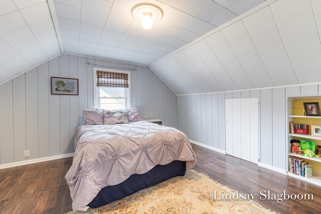 bedroom featuring lofted ceiling, wood finished floors, and baseboards