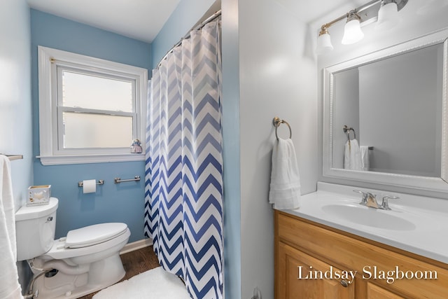 bathroom featuring toilet, vanity, wood finished floors, a shower with curtain, and baseboards