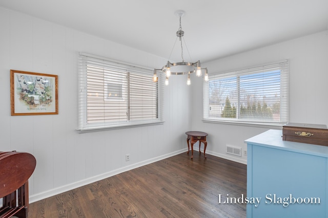 dining space with dark wood-style flooring, visible vents, and baseboards