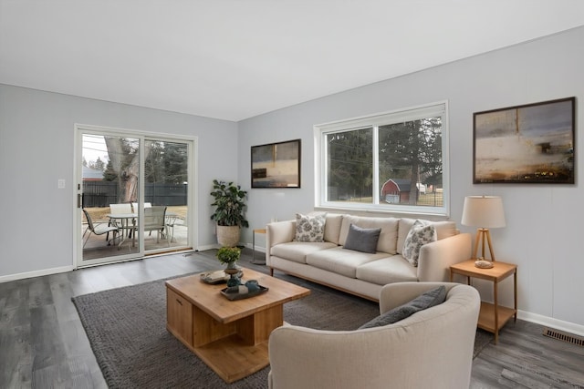 living area featuring visible vents, baseboards, and wood finished floors