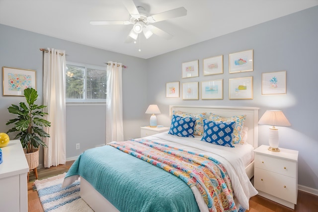 bedroom with a ceiling fan, baseboards, and wood finished floors