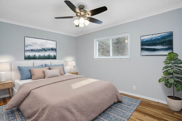 bedroom with ornamental molding, ceiling fan, baseboards, and wood finished floors