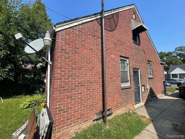 view of side of home featuring crawl space and brick siding