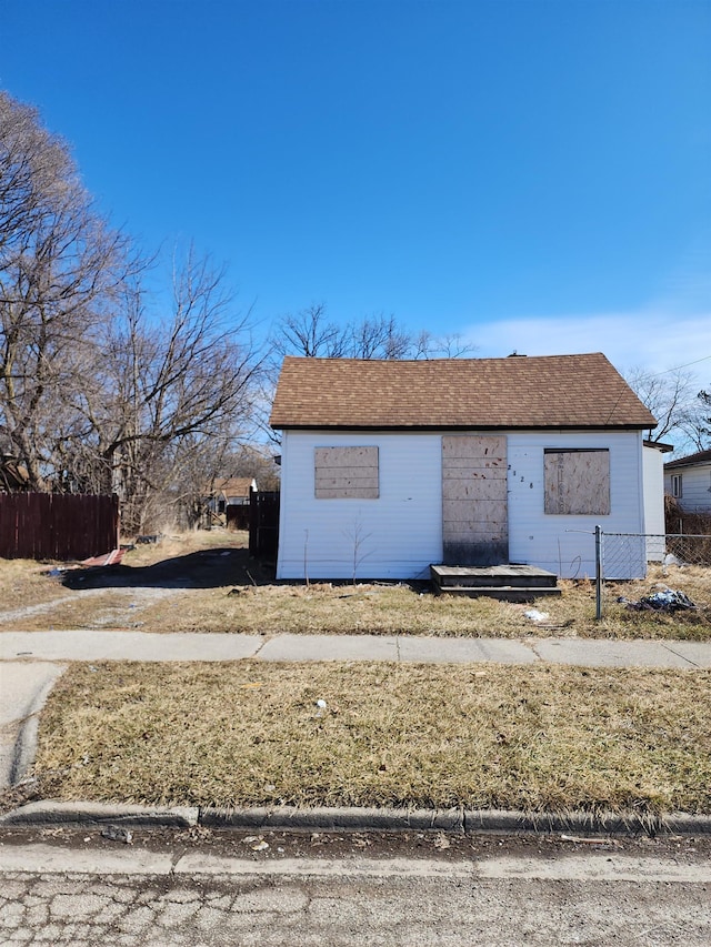 view of front of home featuring fence and roof with shingles