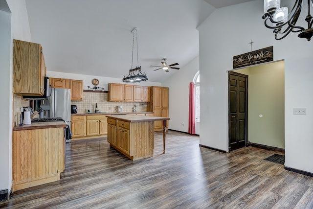 kitchen featuring a sink, dark wood-style floors, a center island, light countertops, and decorative backsplash