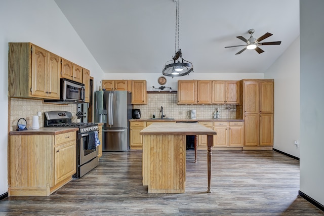 kitchen featuring a sink, stainless steel appliances, dark wood-type flooring, and a center island