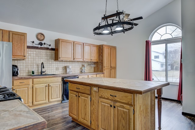 kitchen with a sink, dark wood finished floors, freestanding refrigerator, dishwasher, and vaulted ceiling