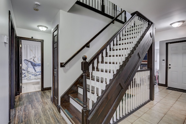 stairway with baseboards and tile patterned flooring