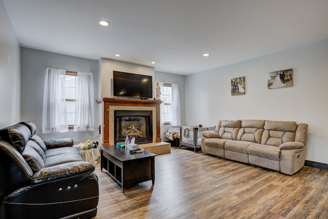 living room with recessed lighting, a fireplace, baseboards, and wood finished floors