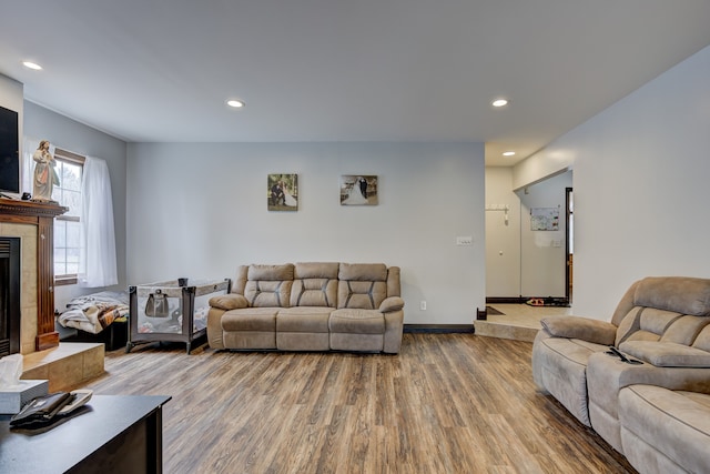 living area featuring recessed lighting, baseboards, wood finished floors, and a tiled fireplace