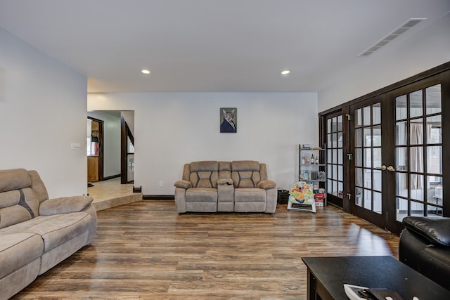 living room featuring wood finished floors, recessed lighting, french doors, and visible vents