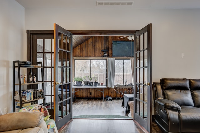 interior space with wood finished floors, french doors, and visible vents