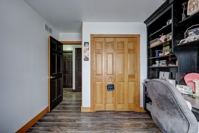 office area with dark wood-style floors, visible vents, and baseboards