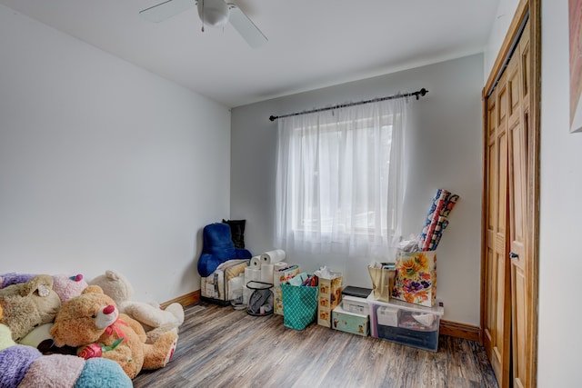 recreation room with wood finished floors, baseboards, and ceiling fan