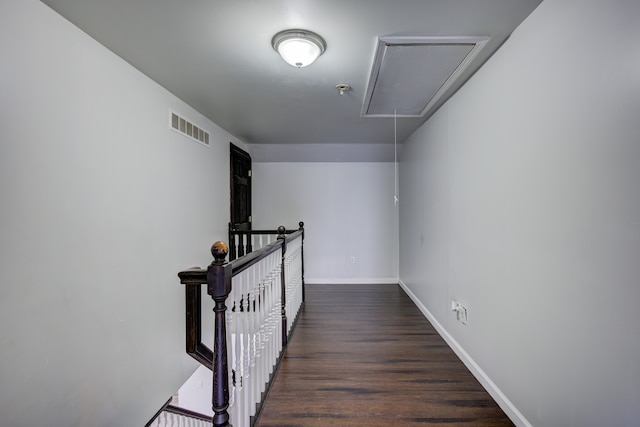 hall featuring visible vents, an upstairs landing, wood finished floors, baseboards, and attic access