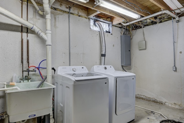 laundry area featuring a sink, laundry area, electric panel, and washing machine and clothes dryer