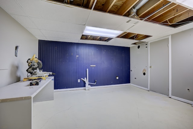 basement featuring a paneled ceiling and visible vents