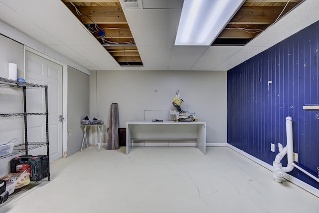 interior space featuring visible vents, baseboards, concrete floors, and a drop ceiling