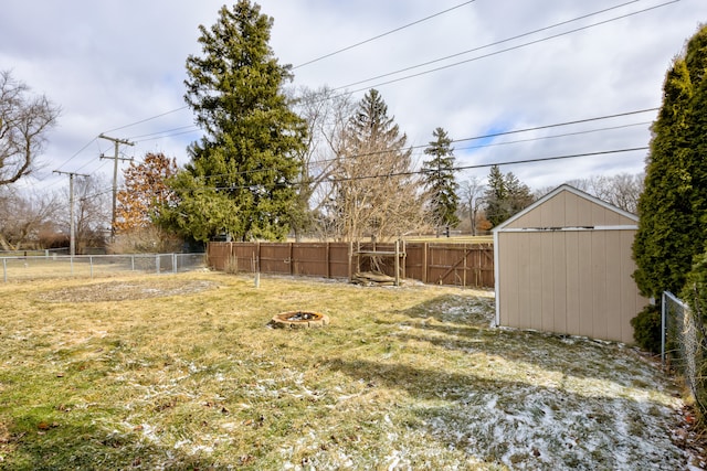 view of yard with a shed, an outdoor fire pit, a fenced backyard, and an outdoor structure