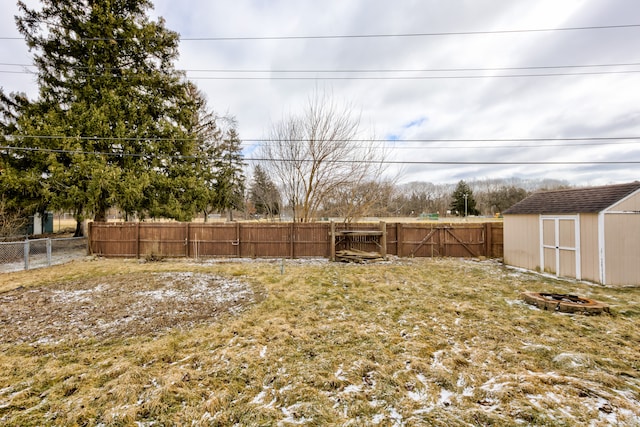 view of yard with an outdoor structure, a fenced backyard, and a shed