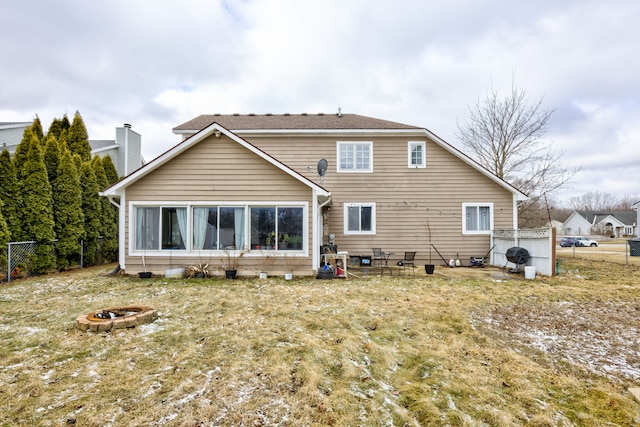 back of house with a fire pit and fence