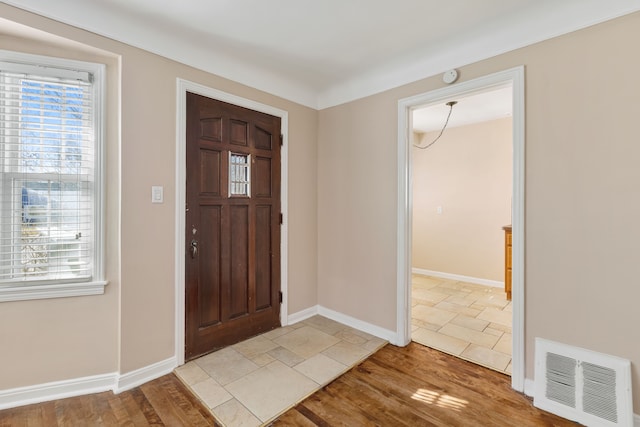 foyer featuring light wood-style floors, visible vents, and a wealth of natural light