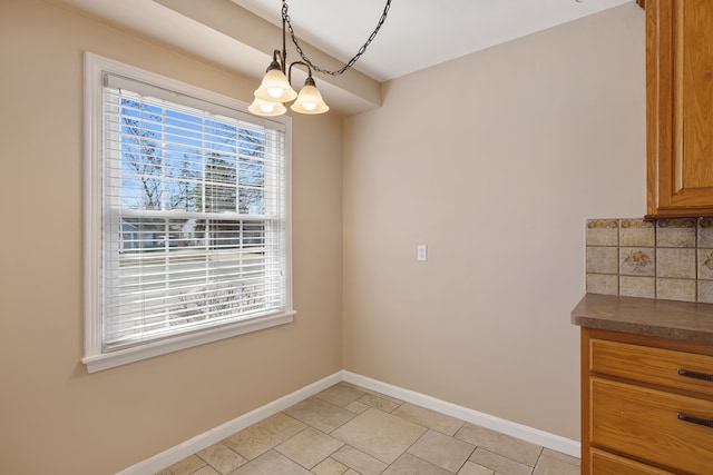 unfurnished dining area with baseboards, plenty of natural light, and light tile patterned flooring