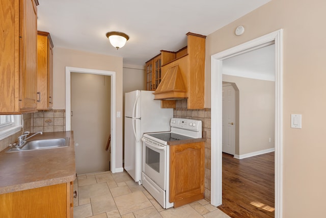 kitchen with white range with electric cooktop, tasteful backsplash, baseboards, and a sink