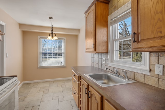 kitchen featuring pendant lighting, a sink, tasteful backsplash, white range with electric stovetop, and baseboards