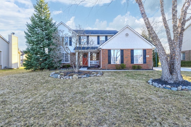 view of front facade with brick siding and a front yard