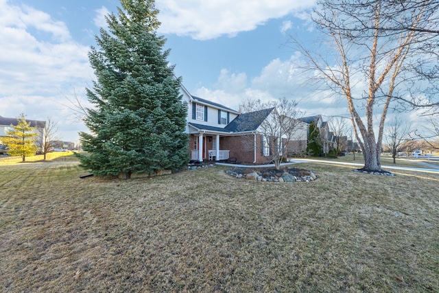 view of front of home featuring a front lawn and brick siding